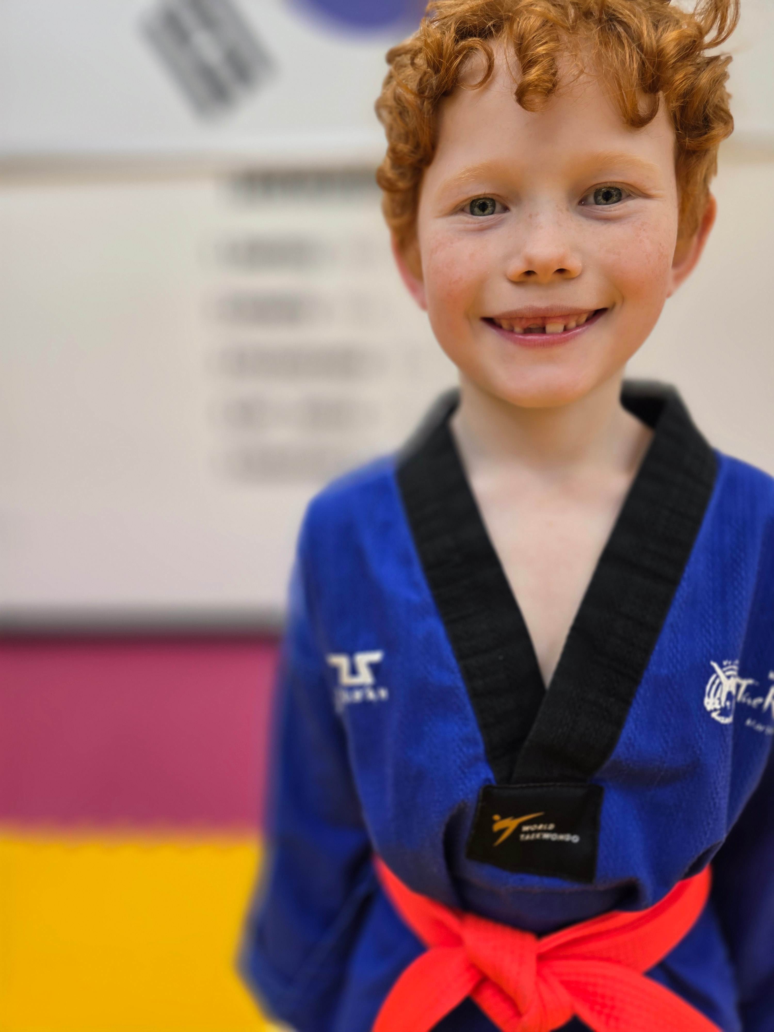 Red-haired student in a blue uniform with a red belt